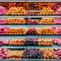 Colorful variety of fresh fruits neatly arranged on supermarket shelves, showcasing abundance and freshness.